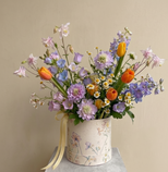 Bouquet of colorful flowers in a decorative box on a neutral background
